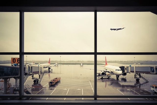 空港の窓から見える滑走路と飛行機