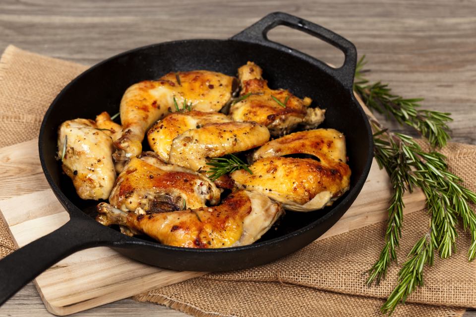 スキレットに乗っている焼いた手羽先肉の写真