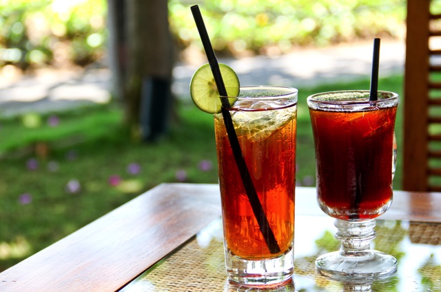 木のテーブルに置かれたアイスティーとアイスコーヒー