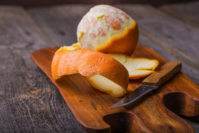 木のまな板の上でカットされた柑橘