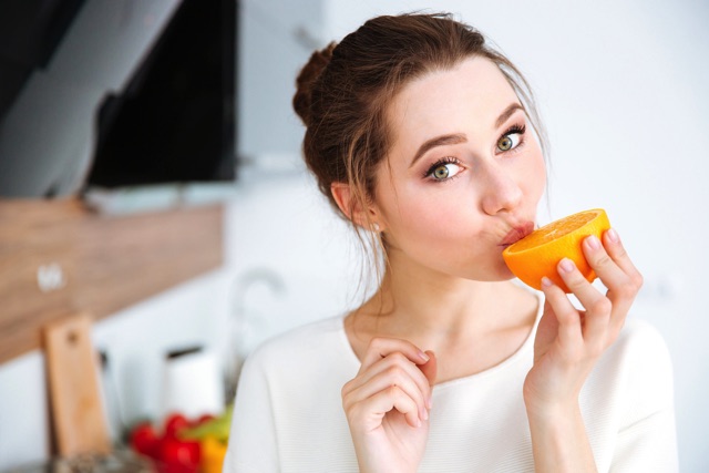 みかんを食べている女性
