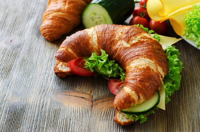 トマト、レタス、きゅうり、チーズを使ったクロワッサンのサンドイッチ