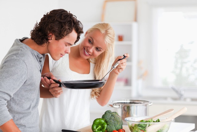フライパンを使って調理している男女
