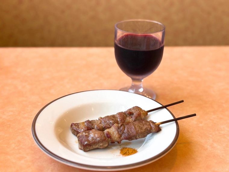 赤ワインとラム肉の串刺しが並ぶ