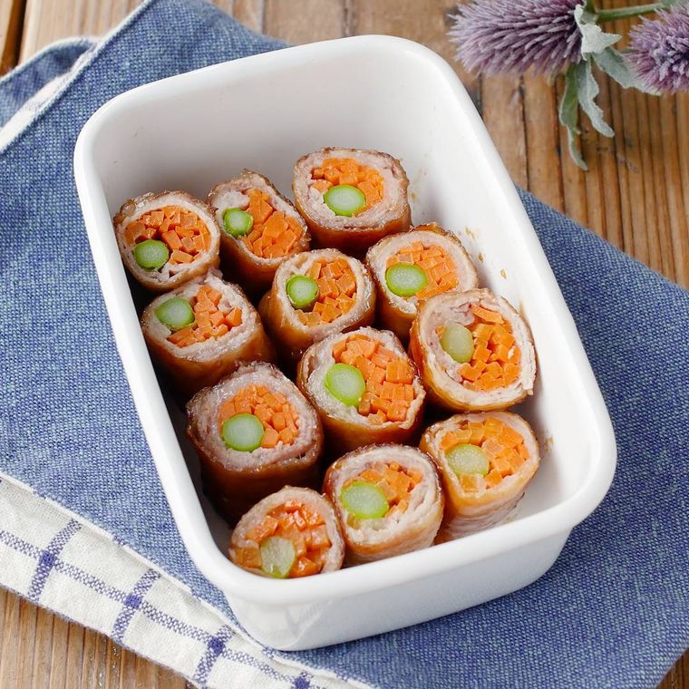 白い容器に入れたアスパラガスとにんじんの肉巻き