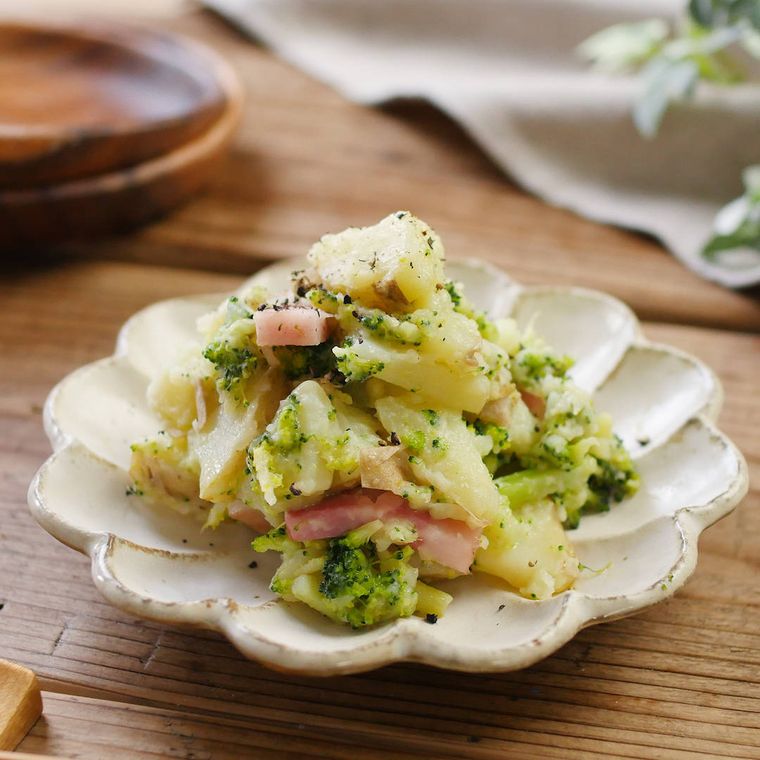 白い花型の皿に盛り付けられたじゃがいもとブロッコリーのホットサラダ