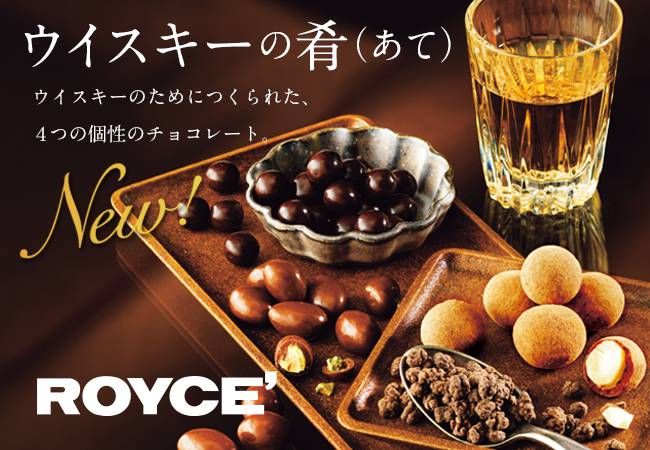 グラスに入ったウイスキーと4種類のチョコレートが置いてある