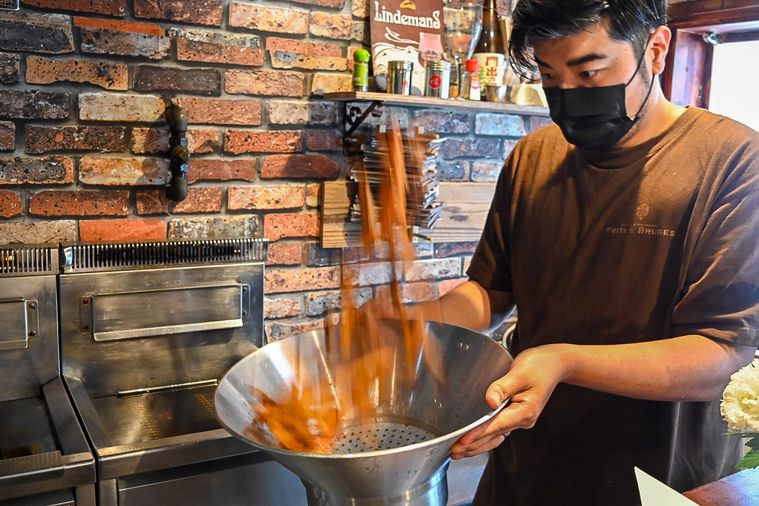 浅草のFrites Bruges（フリッツ・ブルージュ）のポテトをふるっているところ