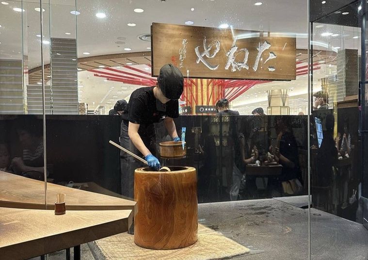 たねやの店頭で臼を使って餅をついている様子