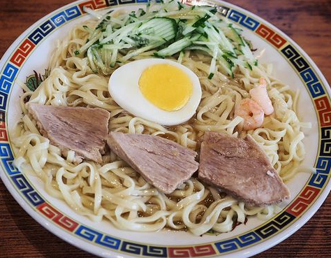 中華柄の器に盛られた呉もんの呉冷麺。トッピングはキュウリ、エビ、チャーシュー、ゆで玉子