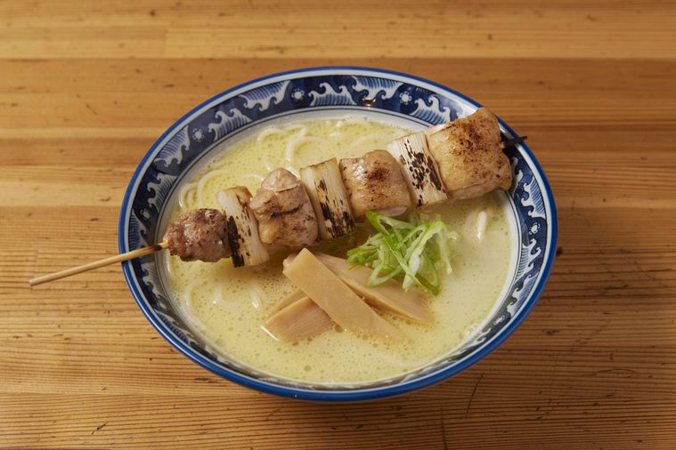 どんぶりの中に焼き鳥がのったラーメンが入って置いてある