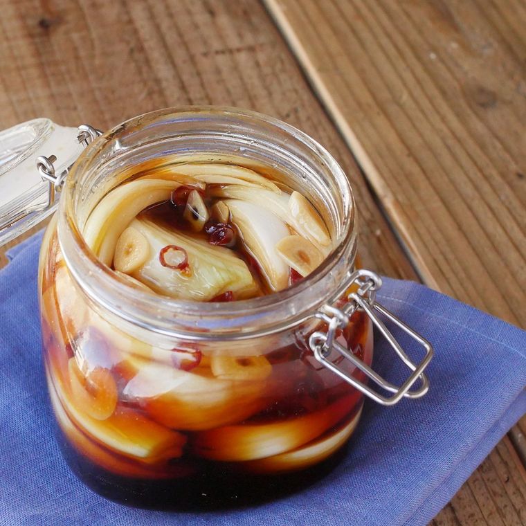 透明のガラス瓶に新玉ねぎのにんにくしょうゆ漬けが入っている