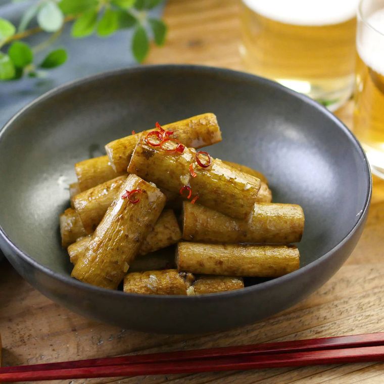 黒い丸皿にペペロンチーノごぼうが盛られている