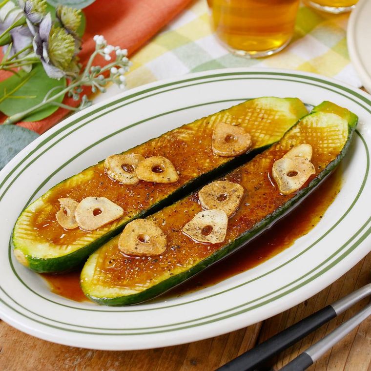 楕円形の皿にズッキーニのステーキが盛られている