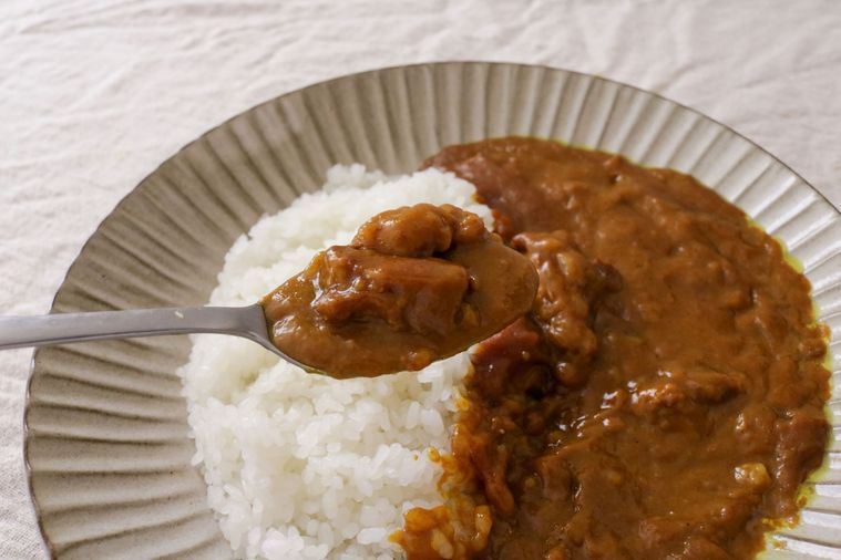 カレーをスプーンですくっている手元