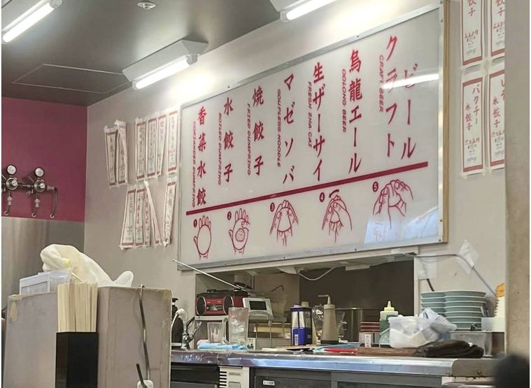 カウンター越しに見える店内のメニュー看板と調理場