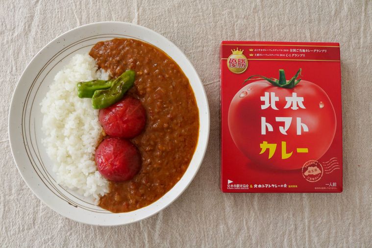 トマトがのったカレーライスと赤いパッケージ