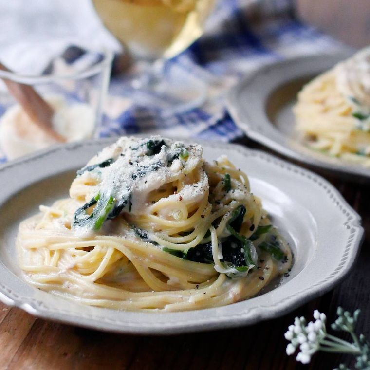 白い皿に盛り付けられたツナとほうれん草のクリームパスタ