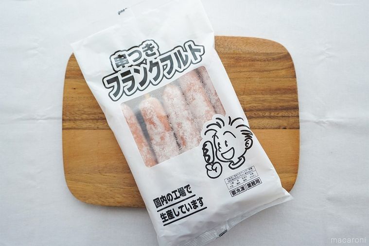 木のまな板にのせた串つきフランクフルトのパッケージ