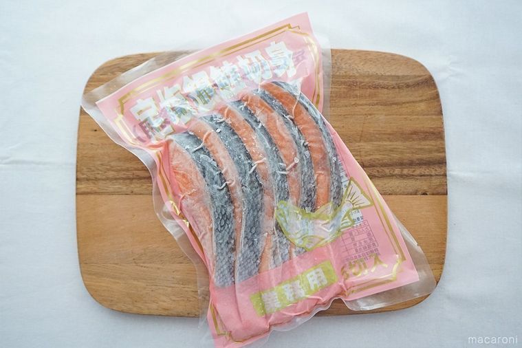 木のまな板にのせた冷凍定塩銀鮭切身のパッケージ