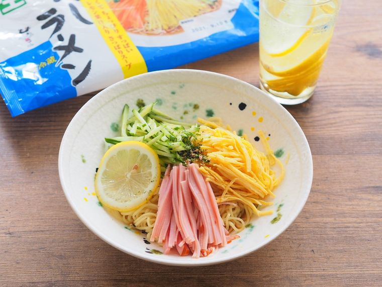 ハム、きゅうり、錦糸卵、レモンスライスがトッピングされたSugakiya 冷しラーメンとパッケージ