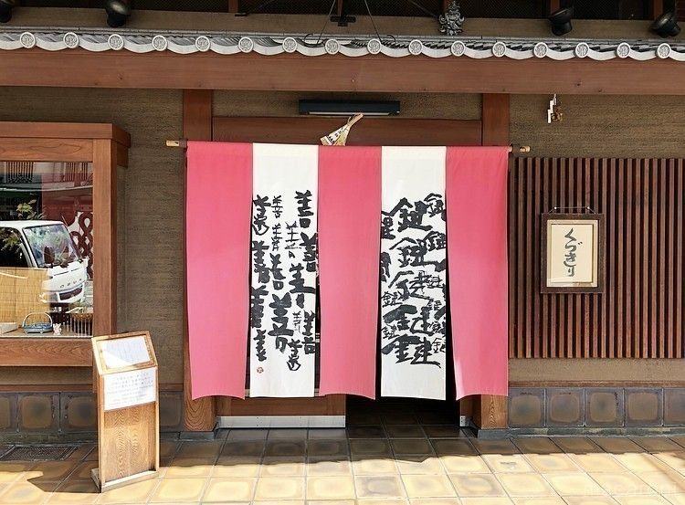 鍵と善の文字が入り紅白暖簾のかかった鍵善良房 四条本店の外観
