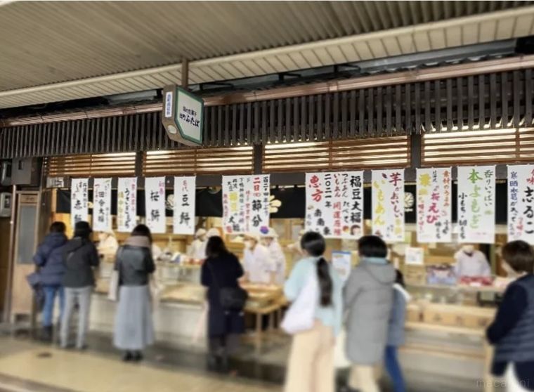 メニュー短冊と並ぶ人が見える出町ふたばの外観