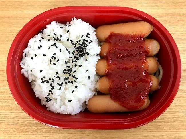 ご飯とウインナーが入ったお弁当がおいてある