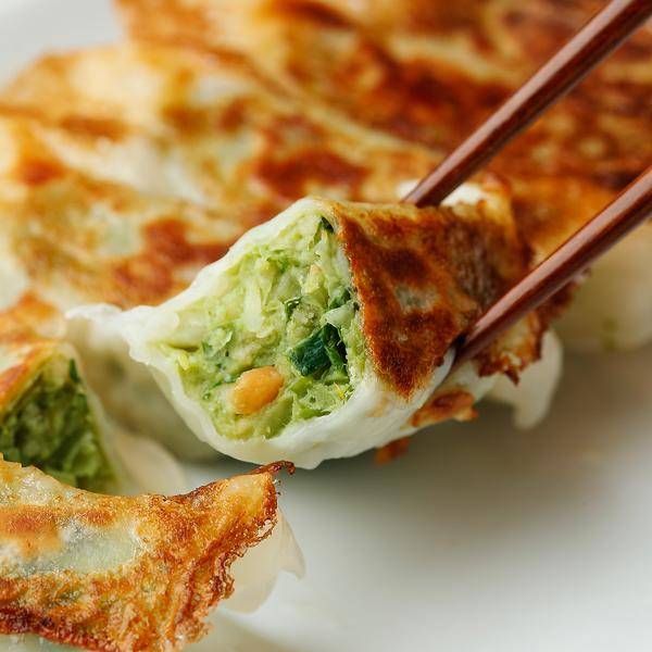 箸で餃子を持ち上げている