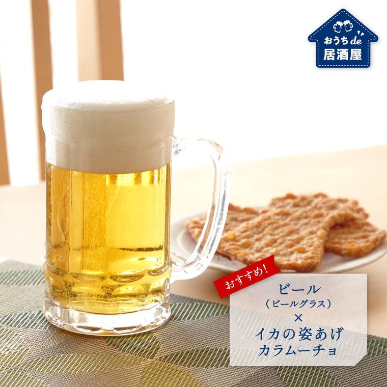 ビールの入ったジョッキといかの姿揚げののったお皿がテーブルの上に置かれている