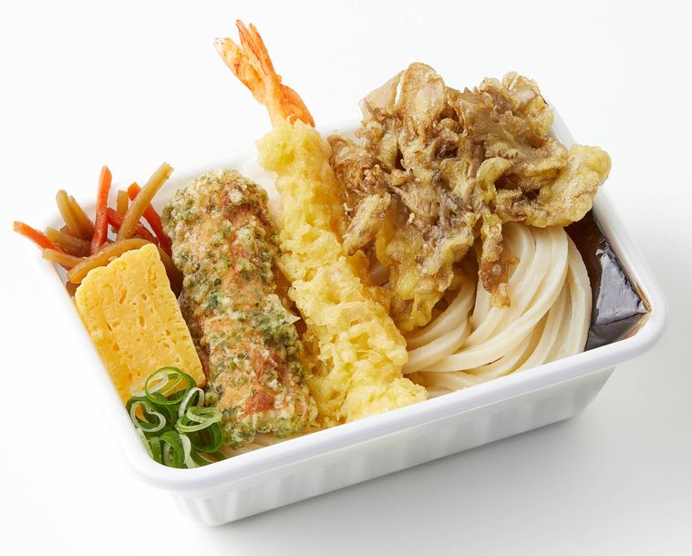 白い容器に入った「えび天とまいたけ天定番おかずのうどん弁当」