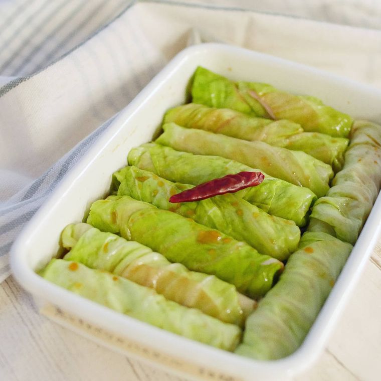 長方形の器に蒸しキャベツのハムロールが入っている