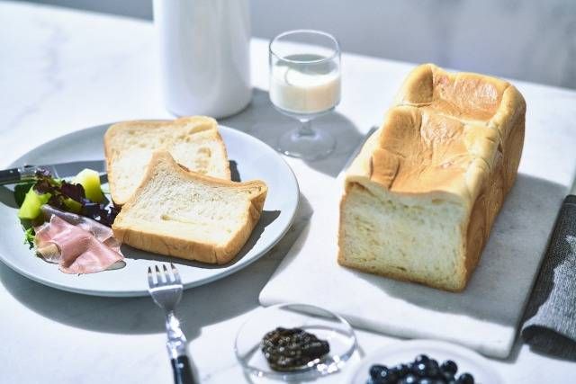 テーブルの上に食パンやハムなどが置いてある