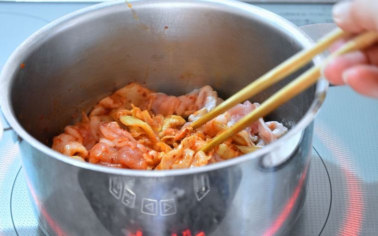 鍋で豚肉とキムチを炒めているところ