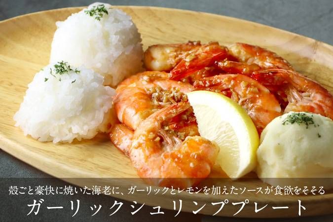 木のプレートの上にご飯とガーリックシュリンプがのっている