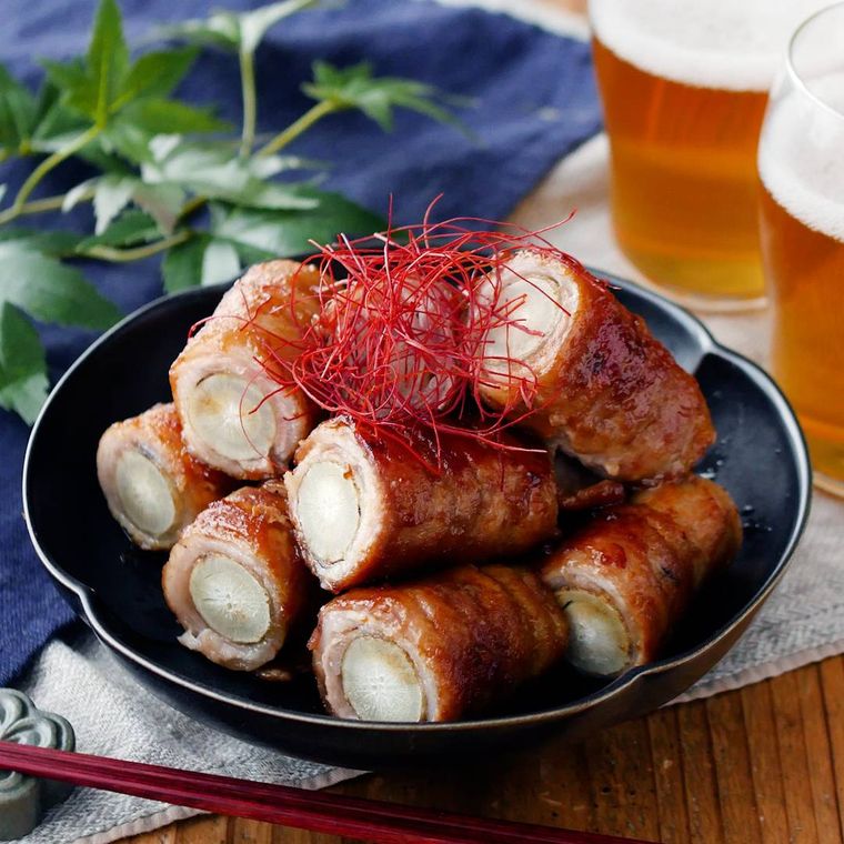 黒い皿に盛り付けられたごぼうの甘辛肉巻き