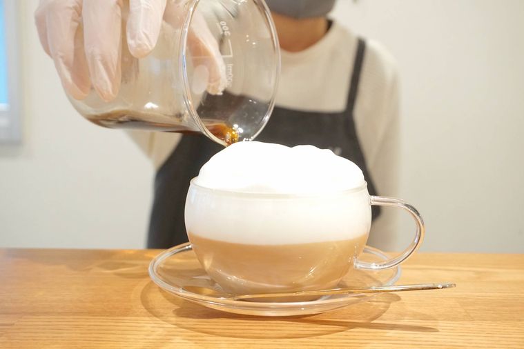 カフェオレにコーヒーを注いでいる