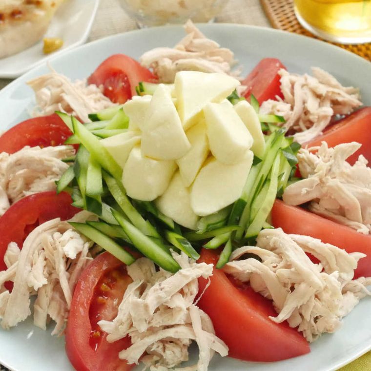 ほぐし鶏むね肉のモッツァレラバンバンジーがカットされたトマトやきゅうりと一緒に盛り付けてある