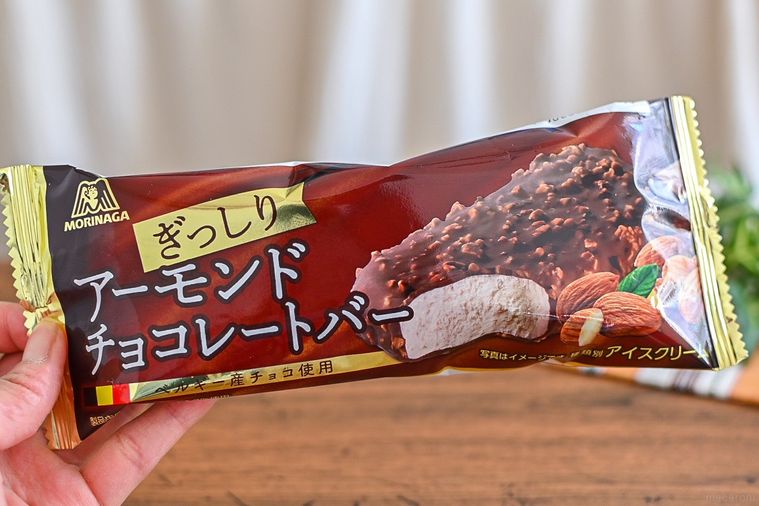 ファミリーマートのアーモンドチョコレートバーのパッケージを持っているところ