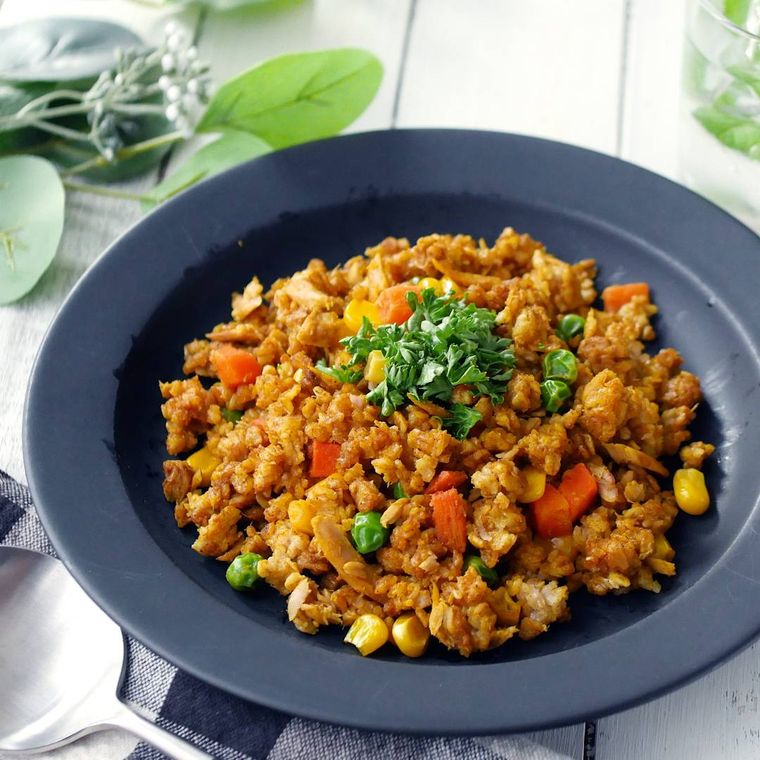 黒い丸皿に盛り付けたオートミールカレーピラフ