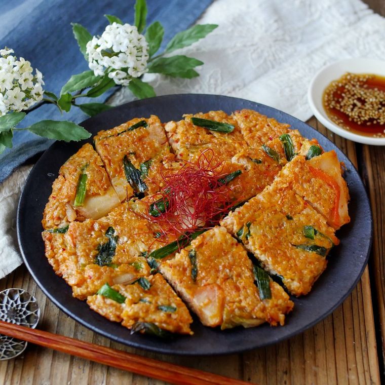 黒い丸皿に盛り付けたオートミールのキムチーズチヂミ