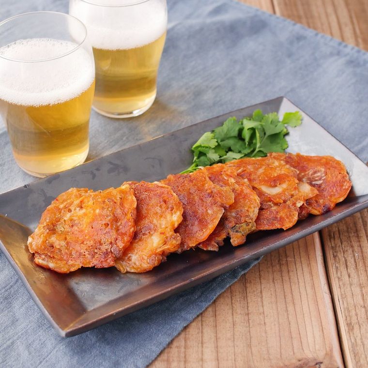 黒い角皿に盛り付けられた納豆と白菜キムチのチーズ焼き