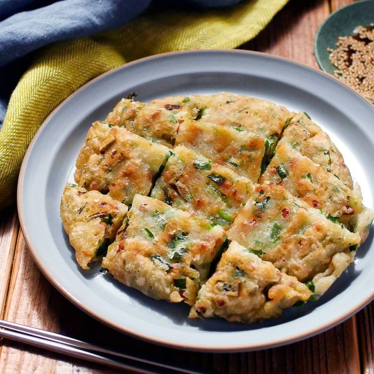 グレーの皿に盛り付けられた納豆とニラのチヂミ