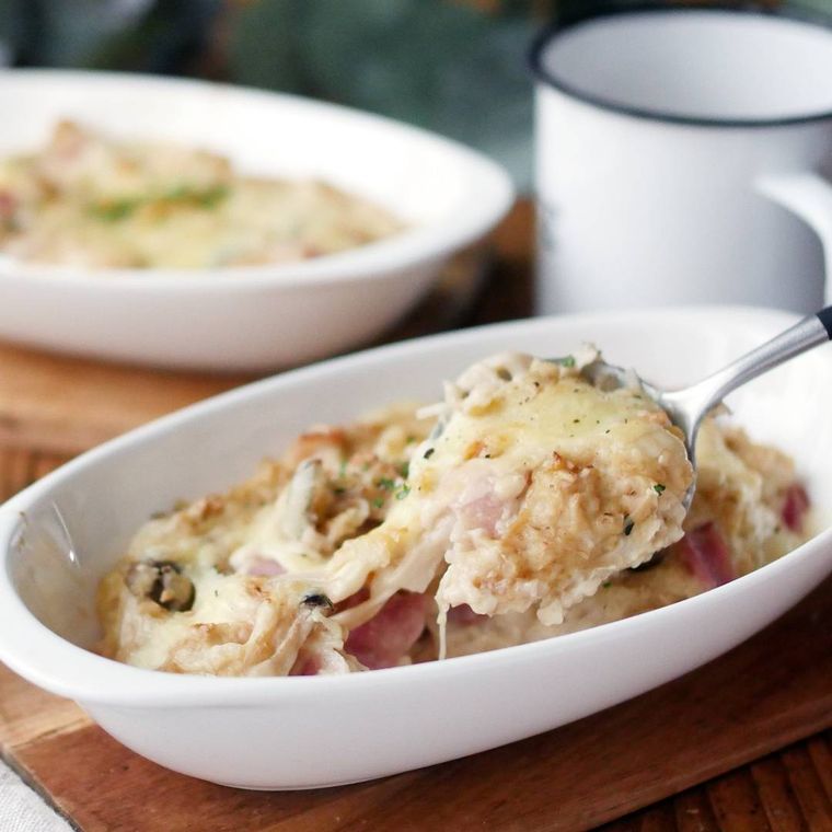 白いグラタン皿からオートミールのきのこドリアをスプーンですくっている様子