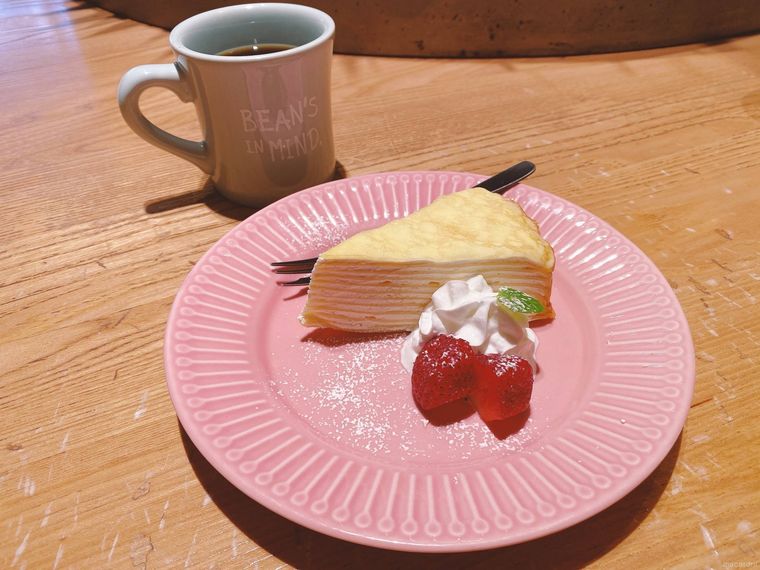 ピンクの皿にのったミルクレープといちご