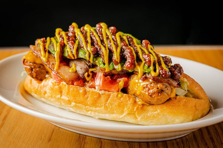 お皿の上にSKOOKUM HOTDOG DINERの「スクーカムドッグ」がのっている