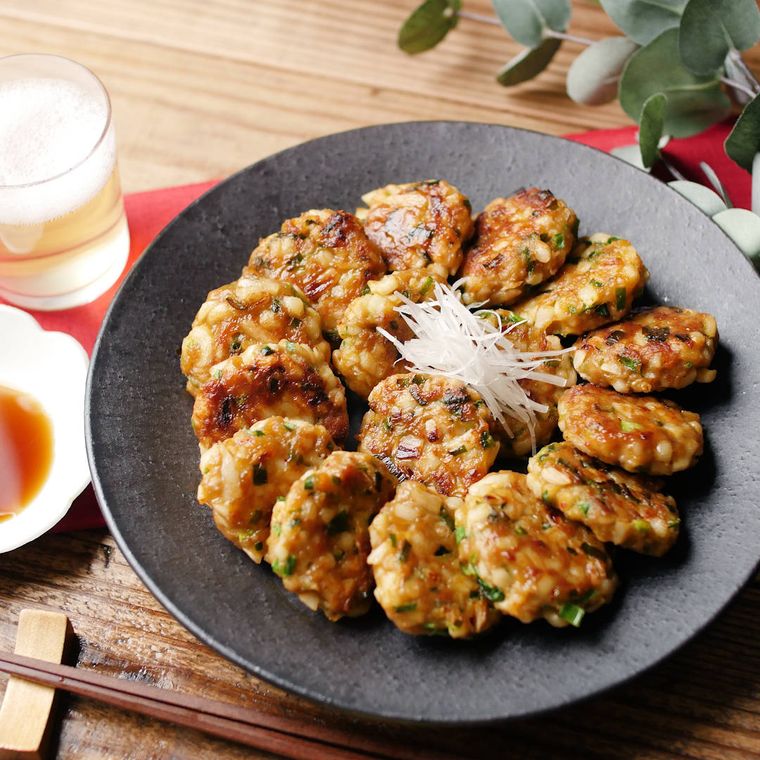 黒灰色の皿に盛りつけられたキムチ入りのうどん餃子