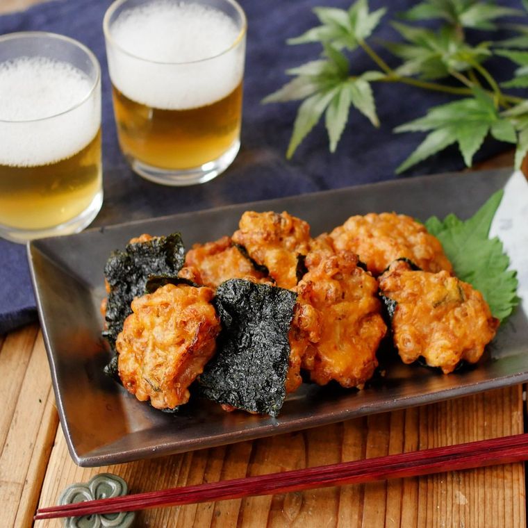 黒灰色の角皿に盛りつけられたキムチと納豆のさつま揚げ風