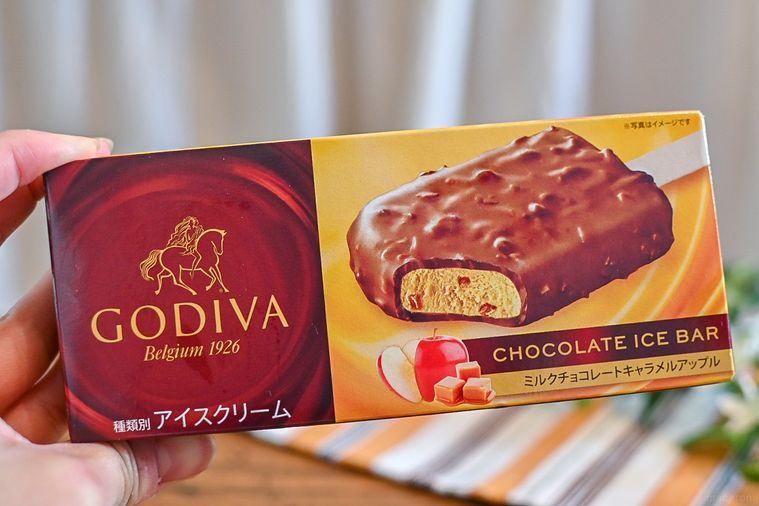 ローソン数量限定のGODIVA ミルクチョコレートキャラメルアップルバーのパッケージを持っているところ