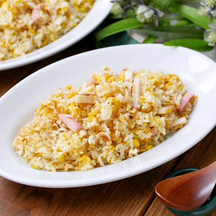 白い皿に盛り付けられたかまぼこと長ねぎのチャーハン